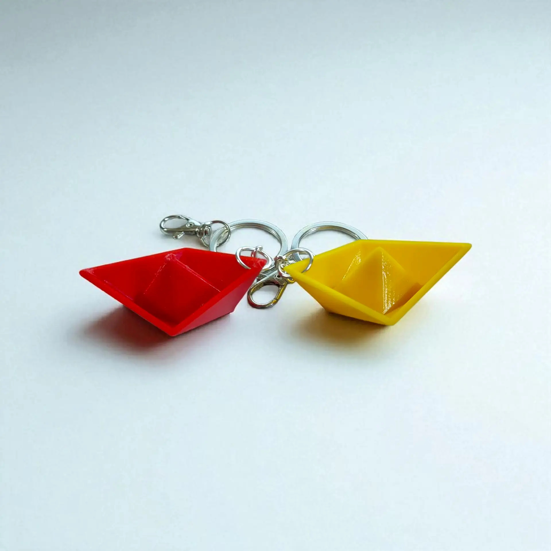 2025/08/1000244707.png mini paper boat keychain combo – red & yellow (set of 2 with lobster locks)